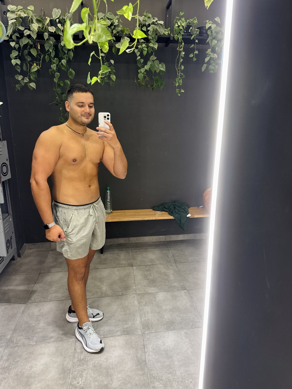 ALEN frente al espejo del gimnasio, sin camiseta y con pantalón corto gris.